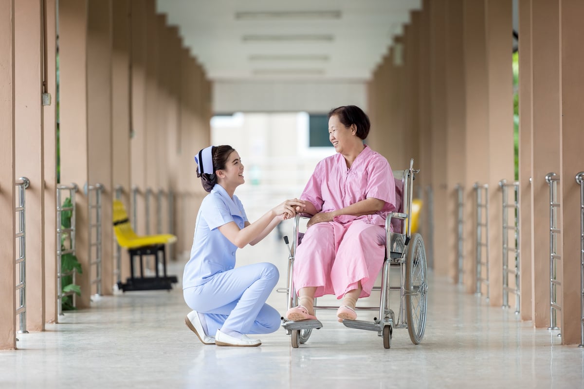 Elder Woman in Wheelchair with Caregiver